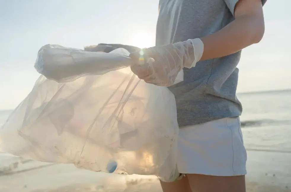 Someone picking up single-use plastic bottles