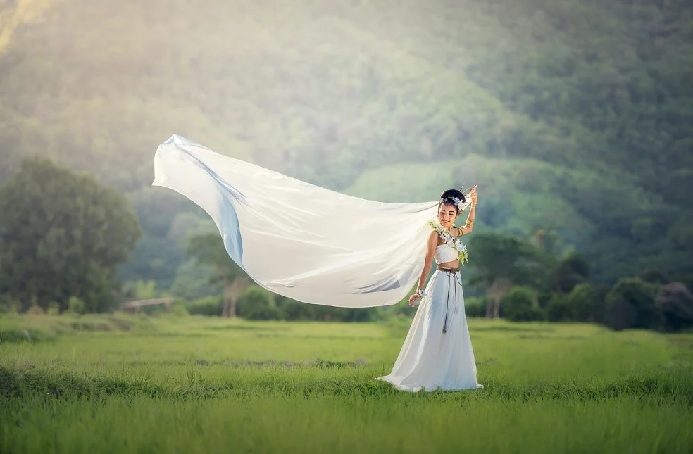 Woman with a flowing veil in a field