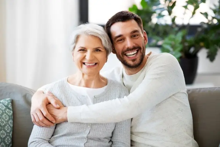 Adult son hugging mother