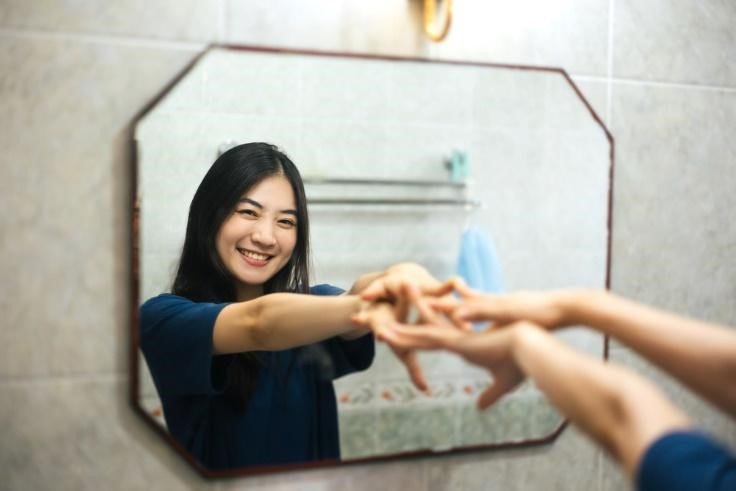 Happy woman smiling into the mirror