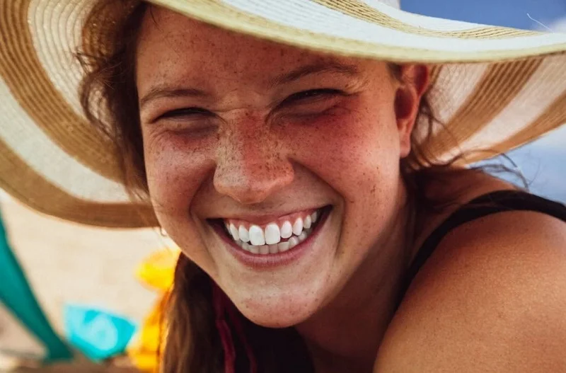 Woman wearing a hat with a broad smile